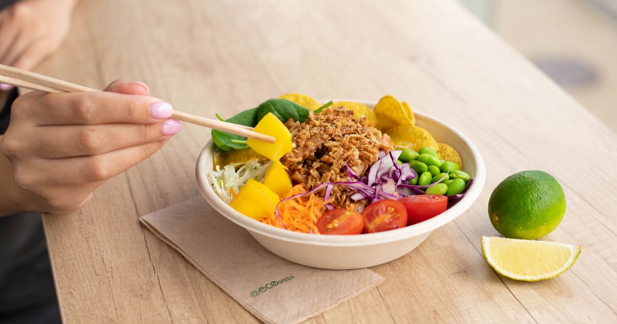 Persona che gusta una ciotola di insalata fresca e colorata
