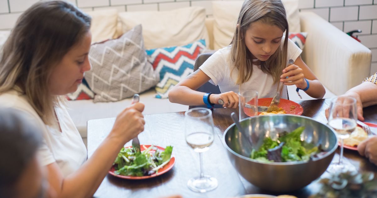Mamma e bambina che mangiano insieme un'insalata colorata