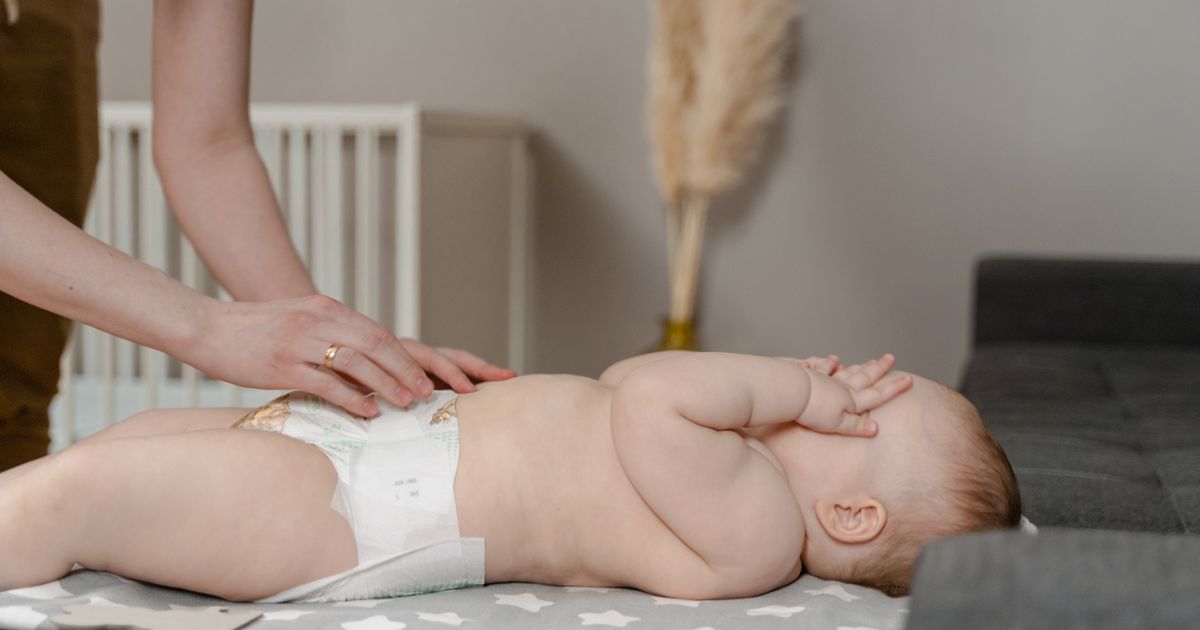 Genitore che cambia il pannolino lavabile a un neonato sul fasciatoio