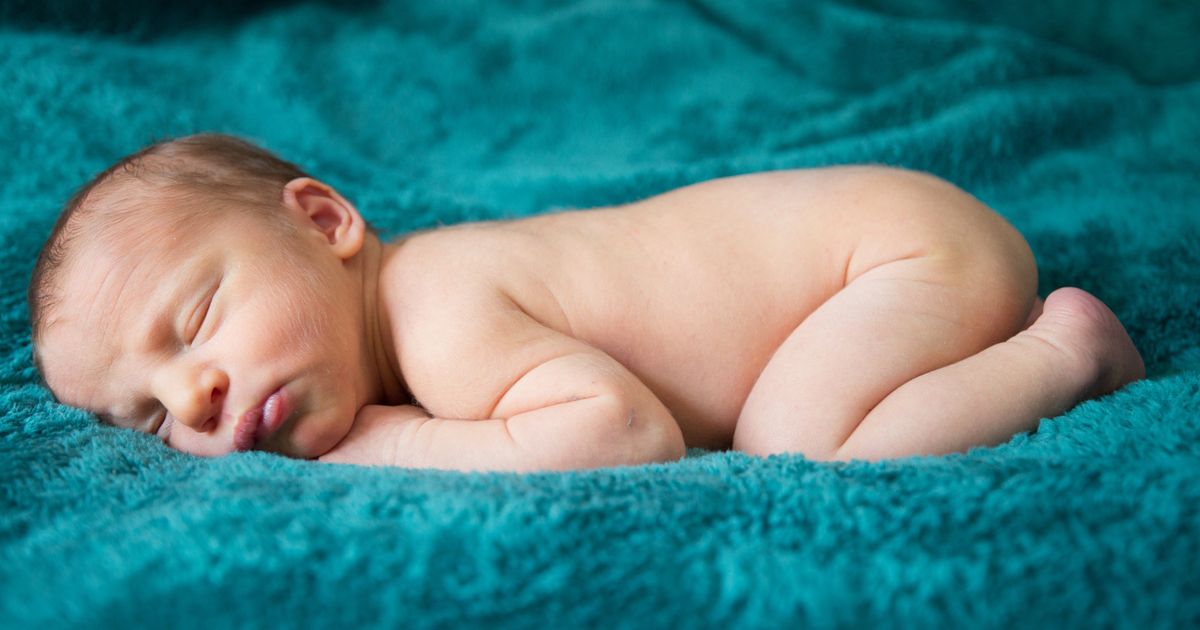 Neonato che dorme sereno in un pannolino lavabile notturno