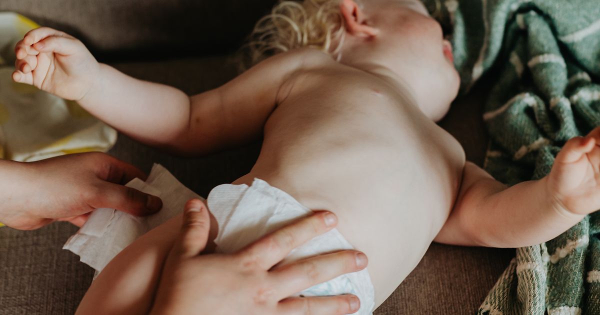 Mamma che cambia il pannolino lavabile al bambino al risveglio