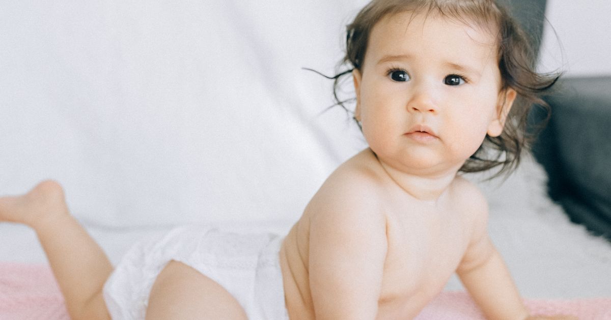 Bambino seduto che indossa un pannolino, a confronto tra lavabili e usa e getta